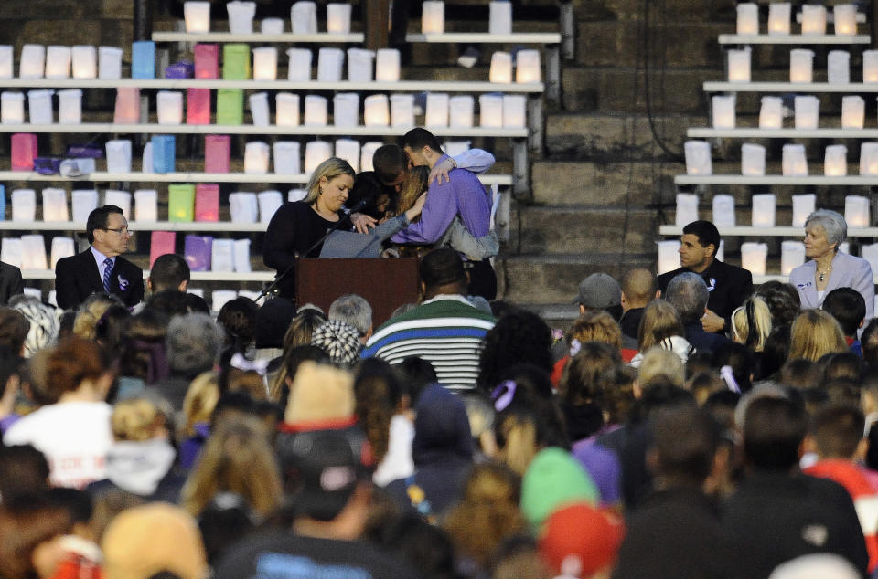 Friends of Maren Sanchez, including boyfriend Jarrod Butts embrace during a vigil for her at Jonathan Law High School, Monday, April 28, 2014, in Milford, Conn. Sanchez was fatally stabbed inside the school on Friday hours before her junior prom. (AP Photo/Jessica Hill)