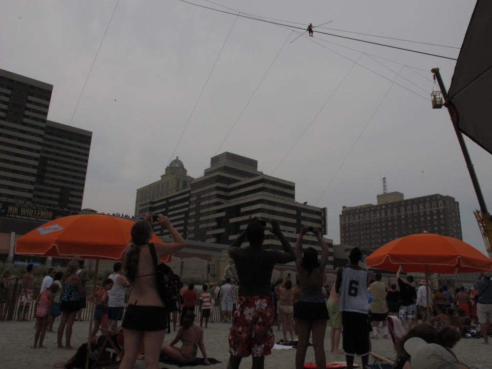 A crowd watches as daredevil Nik Wallenda walks a tightrope above the beach at Atlantic City on Thursday, Aug. 9, 2012. Officials say some 150,000 people witnessed the walk. (AP Photo/Geoff Mulvihill)
