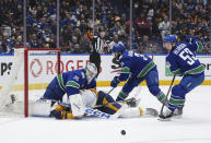 Nashville Predators' Jeremy Lauzon, bottom left, collides with Vancouver Canucks goalie Thatcher Demko (35) as Phillip Di Giuseppe (34) and Teddy Blueger (53) defend during the second period in Game 1 of an NHL hockey Stanley Cup first-round playoff series in Vancouver, British Columbia, on Sunday, April 21, 2024. (Darryl Dyck/The Canadian Press via AP)