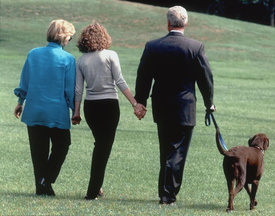 Hillary, Chelsea, and President Bill Clinton walk with Buddy in August 1998 as they leave the White House for vacation. (Photo: Roberto Borea/AP)