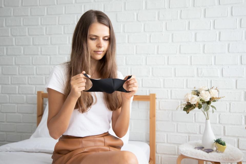 Woman wearing cloth mask or face mask in her apartment