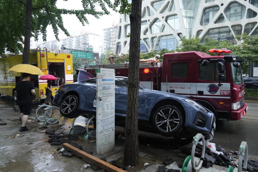 A vehicle sits damaged on a road after floating in heavy rainfall in Seoul, South Korea, Tuesday, Aug. 9, 2022. Heavy rains drenched South Korea's capital region, turning the streets of Seoul's affluent Gangnam district into a river, leaving submerged vehicles and overwhelming public transport systems. (AP Photo/Ahn Young-joon)