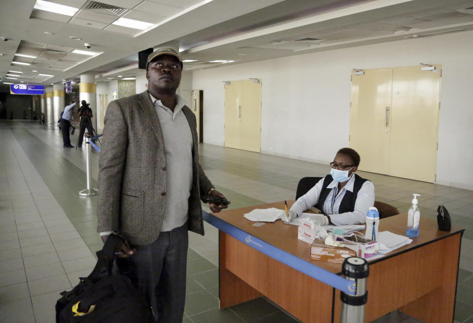 A traveller looks up toward a thermal imaging screen as he is screened for symptoms of Ebola upon his arrival at the Jomo Kenyatta International Airport in Nairobi, Kenya Monday, June 17, 2019. Kenyan doctors are testing a hospital patient in western Kenya who has Ebola-like symptoms, as eastern Congo is struggling to control the outbreak and Uganda has reported two deaths from the deadly hemorrhagic fever, though Kenya's health minister downplayed the threat Monday. (AP Photo/Khalil Senosi)