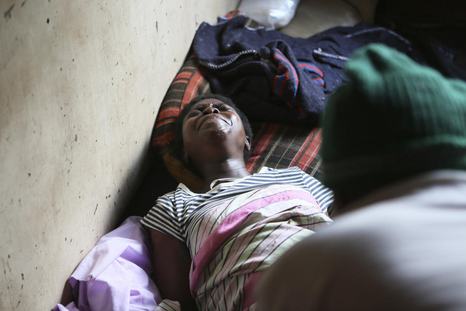 Samantha Nazarere goes into labor in a tiny apartment in the poor Mbare suburb in Harare, Zimbabwe, Saturday, Nov. 16, 2019, to deliver a baby boy with the help of 72-year old grandmother Esther Zinyoro Gwena. Grandmother Esther Zinyoro Gwena claims to be guided by the holy spirit and has become a local hero, as the country’s economic crisis forces closure of medical facilities, and mothers-to-be seek out untrained birth attendants.(AP Photo/Tsvangirayi Mukwazhi)