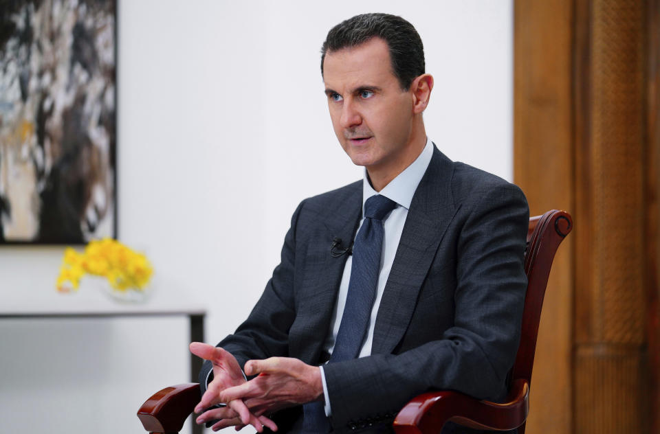 In this photo released on Monday Nov. 9, 2019 by the Syrian official news agency SANA, Syrian President Bashar Assad speaks during an interview with Italy's Rai News 24, in Damascus, Syria. Assad said in an interview aired Monday that the global chemical weapons watchdog has faked and falsified a report over an attack near the capital Damascus last year "just because the Americans wanted them to do so." (SANA via AP)