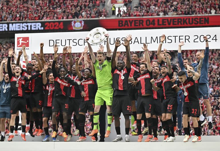 El arquero Lukas Hradecky salta con el trofeo de la Bundesliga en medio de la coronación de Bayer Leverkusen tras su victoria sobre Augsburg en el BayArena.