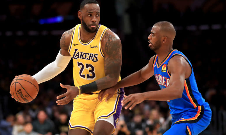 LeBron James of the Los Angeles Lakers backs down Oklahoma City Thunder guard Chris Paul during an NBA game.