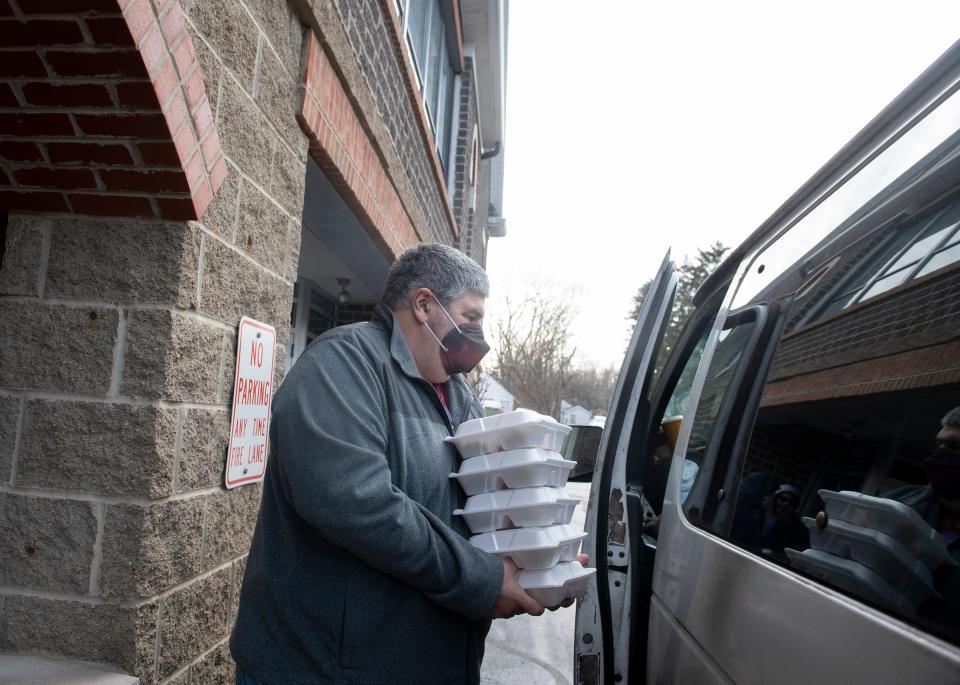 Bill Bowen, Kent Social Services food coordinator, distributes hot meals at Trinity Lutheran Church in Kent. 