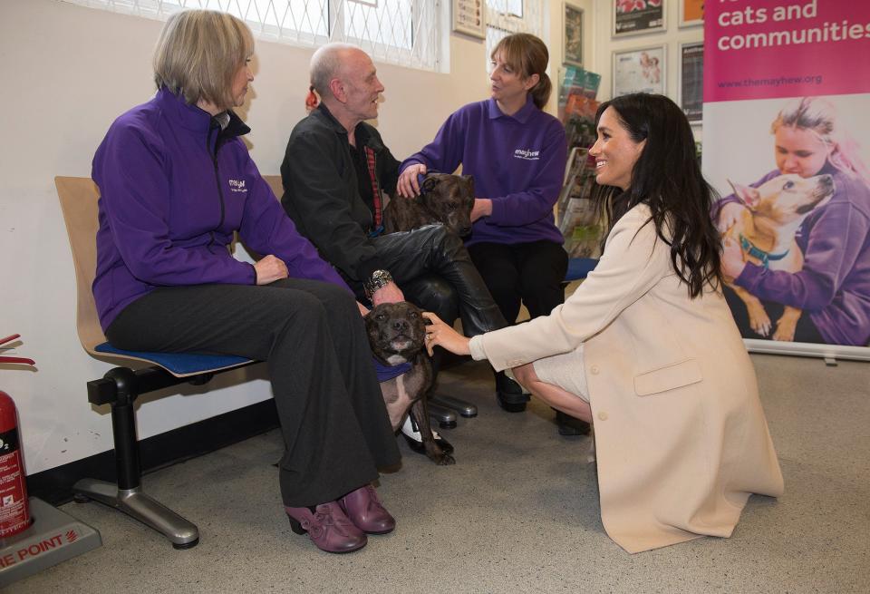 The Duchess of Sussex meets Wully Struthers and his staffies Azzy and Gallis during a visit to animal welfare charity Mayhew (PA Archive)