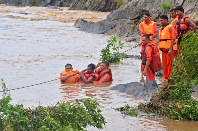 Unos pescadores son rescatadaos en el desbordado río Narmada tras las intensas lluvias monzónicas en Jabalpur, India, el 10 de julio de 2023 (Uma Shankar Mishra)