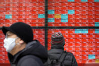 A man wearing a protective mask looks at an electronic stock board showing Japan's Nikkei 225 index at a securities firm Friday, Jan. 28, 2022, in Tokyo. Asian stock markets were mixed Friday as traders looked ahead to data on U.S. employment costs that might influence Federal Reserve decisions on planned interest rate hikes. (AP Photo/Eugene Hoshiko)