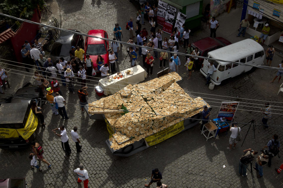 A fake life-sized war tank covered by bread sits on display in the Santa Marta slum as part of a "Bread not Bombs" protest on the sidelines of the Rio+20 UN Conference on Sustainable Development in Rio de Janeiro, Brazil, Tuesday, June 19, 2012. Activists placed the fake war tank covered with bread for residents to eat to protest military spending and demand that military spending be redirected for basic needs. (AP Photo/Silvia Izquierdo)