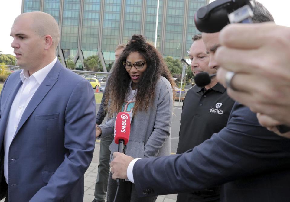 United States' Serena Williams, center, is followed by media as she is escorted to a car on her arrival at Auckland Airport in New Zealand, Friday, Dec. 30, 2016. Williams has announced her engagement to Reddit co-founder Alexis Ohanian. The tennis great posted a poem on the social news website that she accepted his proposal. (Michael Craig/New Zealand Herald via AP)