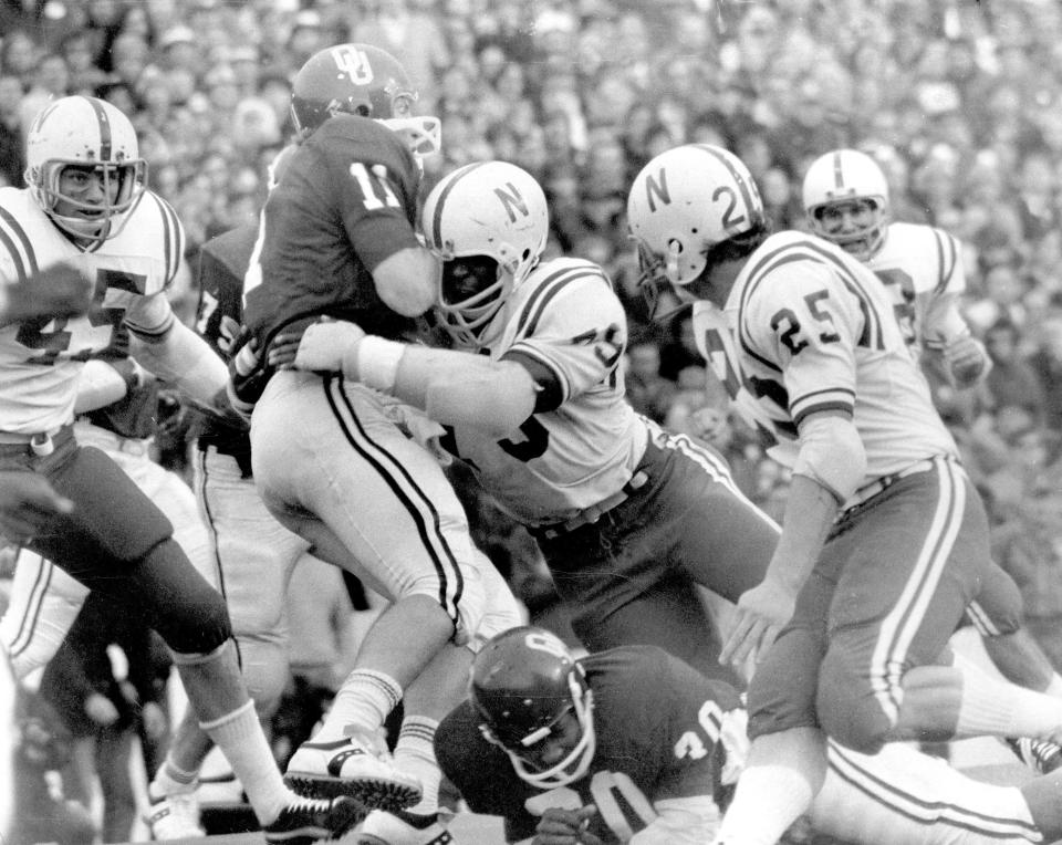 Nebraska's Rich Glover (79) brings down Oklahoma quarterback Jack Mildren (11) during their game in 1971 in Norman, Oklahoma.