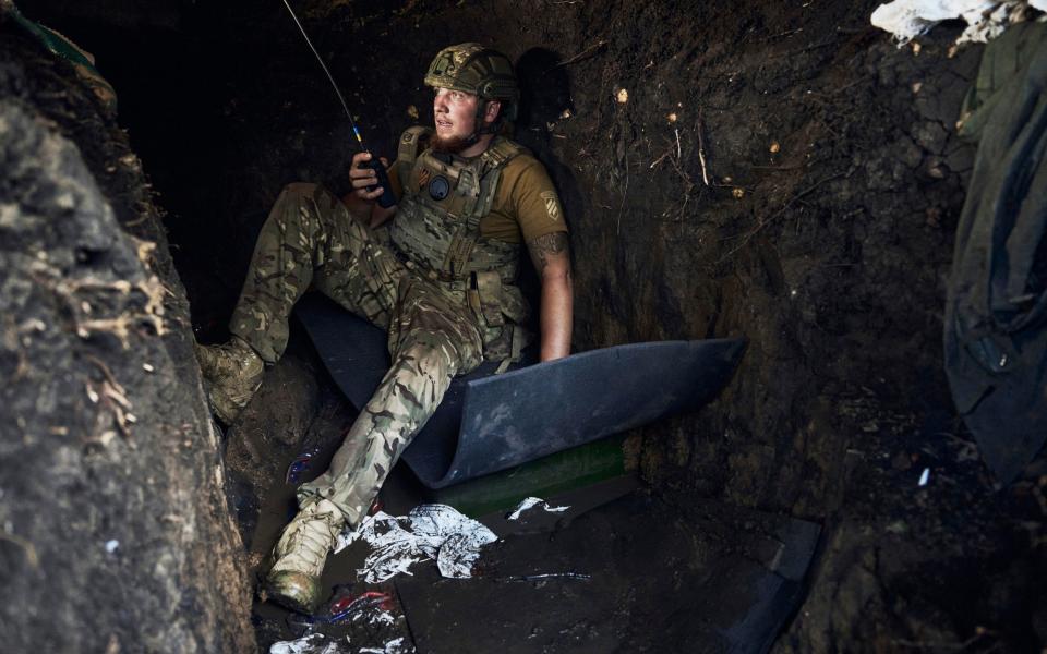 A Ukrainian soldier sits in a trench on the front line near Bakhmut, Donetsk