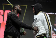 Deontay Wilder, left, shoves Tyson Fury, of England, during a face off for photographers at a news conference for their upcoming WBC heavyweight championship boxing match, Wednesday, Feb. 19, 2020, in Las Vegas. (AP Photo/Isaac Brekken)