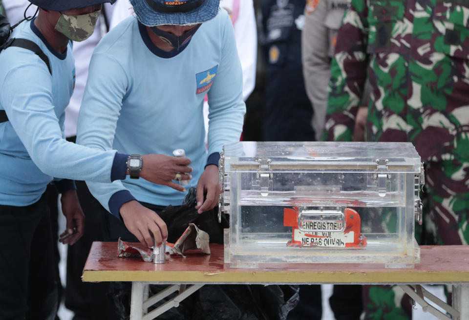 FILE - Indonesian Navy personnel handle a box containing the flight data recorder recovered from the crash site of the Sriwijaya Air flight SJ-182 in the Java Sea at Tanjung Priok Port, on Jan. 12, 2021. Indonesian aviation investigators concluded in their final report Thursday, Nov. 10, 2022, that a nearly decade-long failure to properly repair a malfunctioning automatic throttle, pilots' overreliance on the plane's automation system, and inadequate training led to the crash of a Boeing 737-500 last year that killed 62 people. (AP Photo/Dita Alangkara, File)