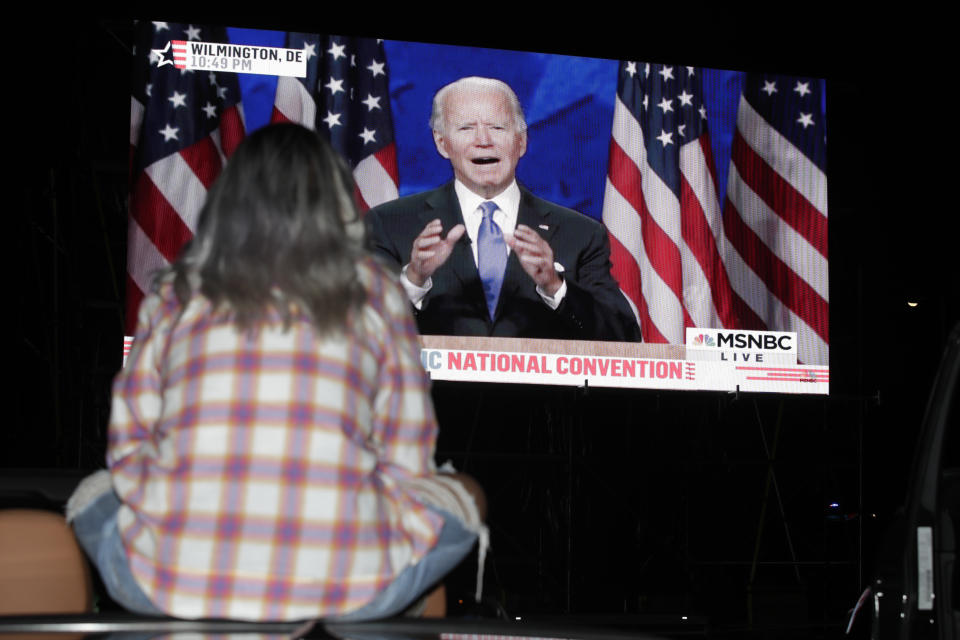 Eva Morales watches Democratic presidential candidate former Vice President Joe Biden speak, during the final day of the Democratic National Convention, Thursday, Aug. 20, 2020, on a screen at a drive-in theater watch party during the final night of the Democratic National Convention, Thursday, Aug. 20, 2020, in Washington. (AP Photo/Luis M. Alvarez)