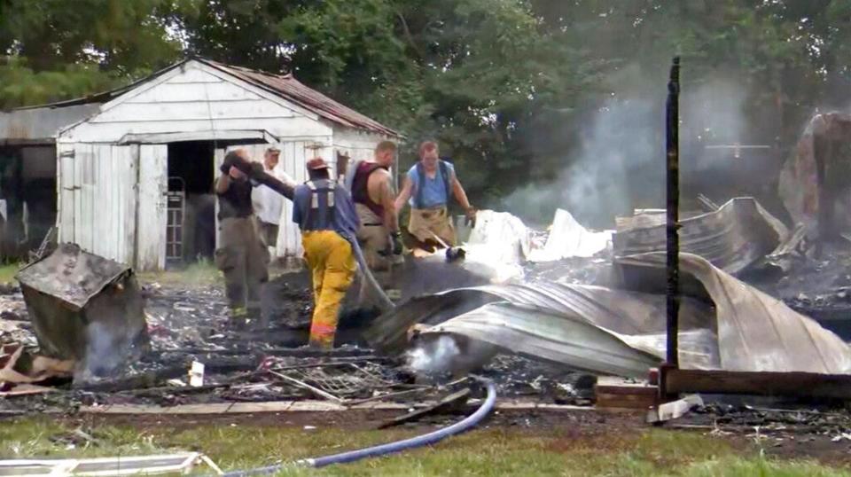 This photo from video by KFVS-TV shows people working the scene of a house explosion in Wyatt Mo., early Monday, Aug. 15, 2022. The house explosion in southeast Missouri has left several people injured and a neighboring home in flames, authorities say.