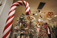 In this Tuesday, Nov. 5, 2019, photo shoppers browse the food-themed decorations in the Holiday Lane section at the Macy's flagship store, in New York. With three weeks until the official start of the holiday shopping season, the nation’s retailers are gearing up for what will be another competitive shopping period. (AP Photo/Richard Drew)