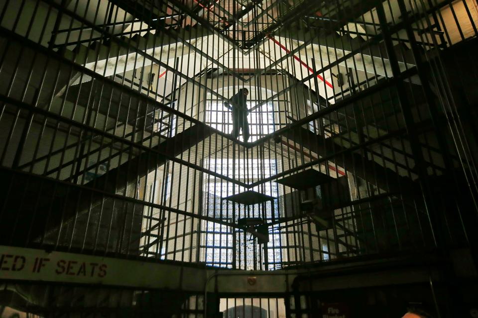 Bristol County corrections officers are seen walking past the 'cage' central section of the Ash Street jail in New Bedford which Sheriff Paul Heroux plans on closing.