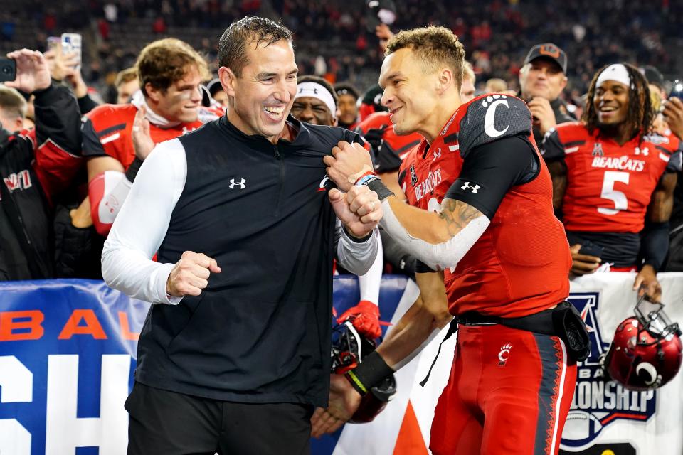 Cincinnati Bearcats head coach Luke Fickell, left, and Cincinnati Bearcats quarterback Desmond Ridder (9) celebrate the victory in the American Athletic Conference championship football game, Saturday, Dec. 4, 2021, at Nippert Stadium in Cincinnati. The Cincinnati Bearcats defeated the Houston Cougars, 35-20. 