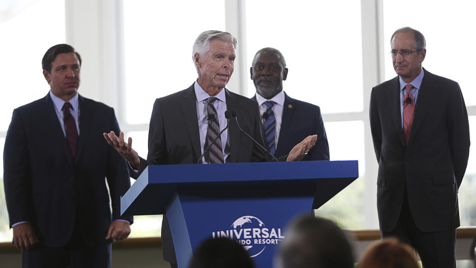Tom Williams, Chairman & CEO Universal Parks & Resorts, speaks, as from left, Florida Gov. Ron DeSantis; Orange County Mayor Jerry Demings; and Brian L. Roberts, Chairman & CEO Comcast Corporation, listen during a press conference at the Orange county Convention Center in Orlando, Fla., Thursday, Aug. 1, 2019. Universal Orlando officials announced that the resort is doubling in size with plans for a fourth theme park. (Ricardo Ramirez Buxeda/Orlando Sentinel via AP)