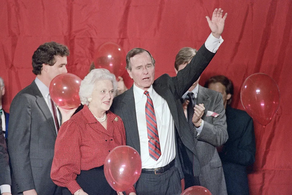 FILE - Vice President George H.W. Bush and Barbara Bush wave as balloons are dropped during a welcome rally in Houston, Nov. 8, 1988. (AP Photo/John Duricka, File)