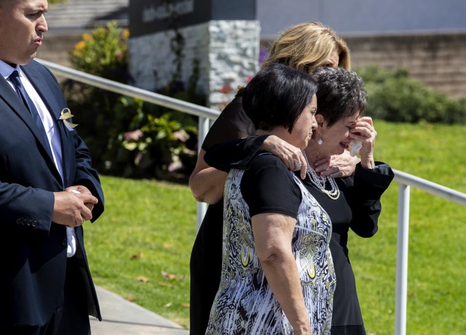 Family members grieve as the casket of 6-year-old Aiden Leos is put into a hearse after his funeral service Saturday.