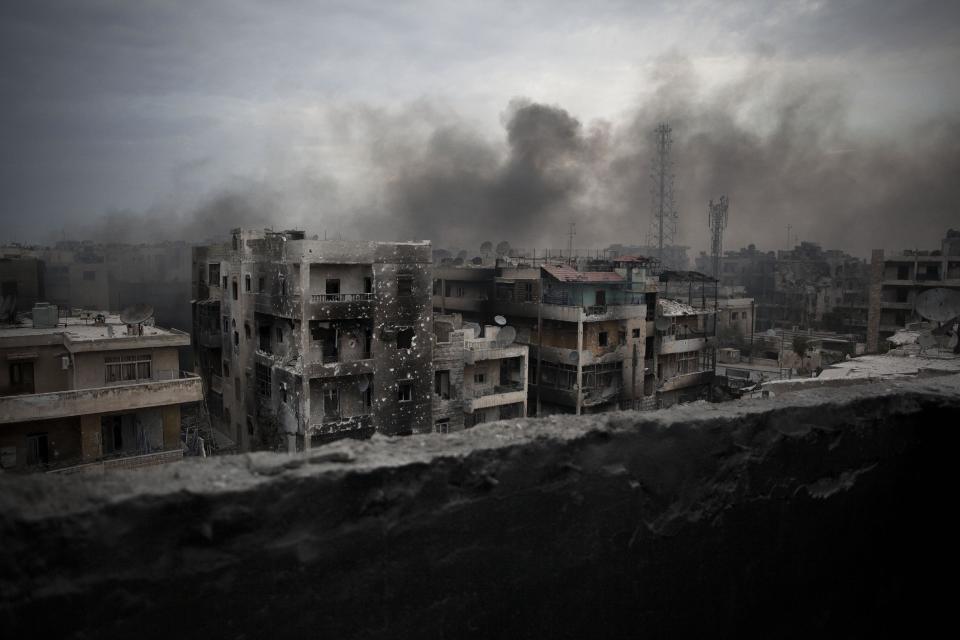 FILE - In this Tuesday, Oct. 2, 2012 file photo, smoke rises over Saif Al Dawla district, in Aleppo, Syria. Syria’s uprising was not destined to be quick. Instead, the largely peaceful protest movement that spread across the nation slowly turned into an armed insurgency and eventually a full-blown civil war. More than 130,000 people have been killed, and more than 2 million more have fled the country. Nearly three years after the crisis began, Syria's government and opposition are set to meet in Geneva this week for the first direct talks aimed at ending the conflict. (AP Photo/ Manu Brabo, File)