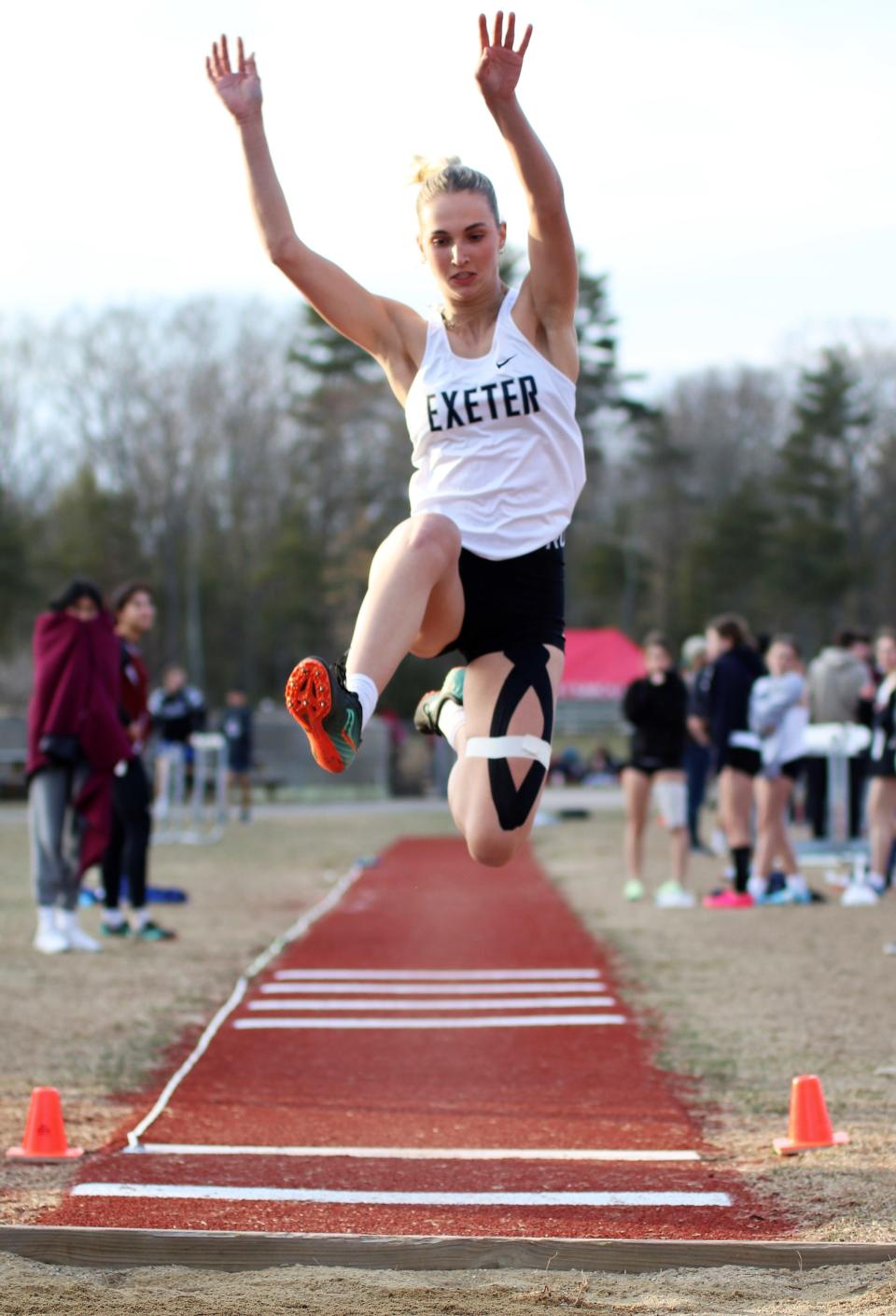 Exeter's Rachel Poulin soars to a first-place performance in the long jump (15-9) at Tuesday's season-opening tri-meet with Portsmouth and Winnacunnet.