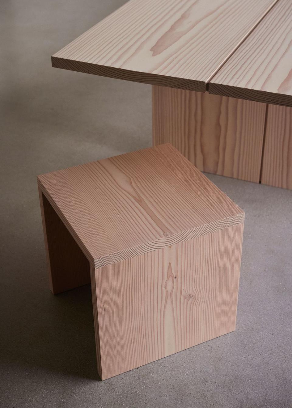 a wooden boxy seat and table edge on a carpet