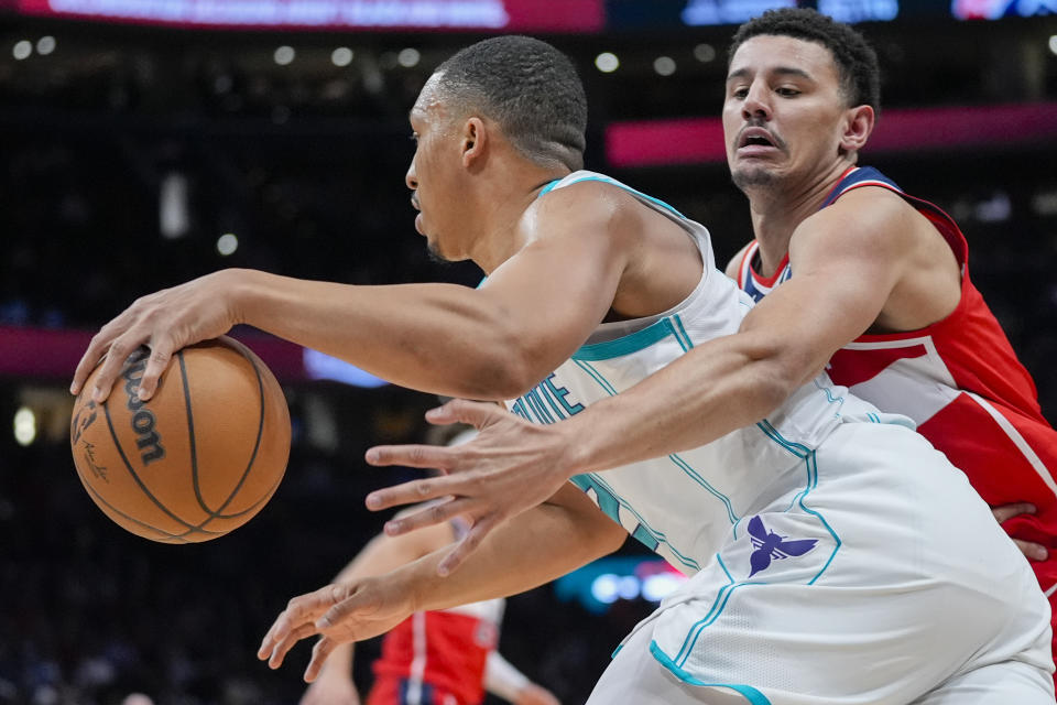 Charlotte Hornets forward Grant Williams (2) tries to get past Washington Wizards guard Johnny Davis during the first half of an NBA basketball game Friday, March 8, 2024, in Washington. (AP Photo/Alex Brandon)