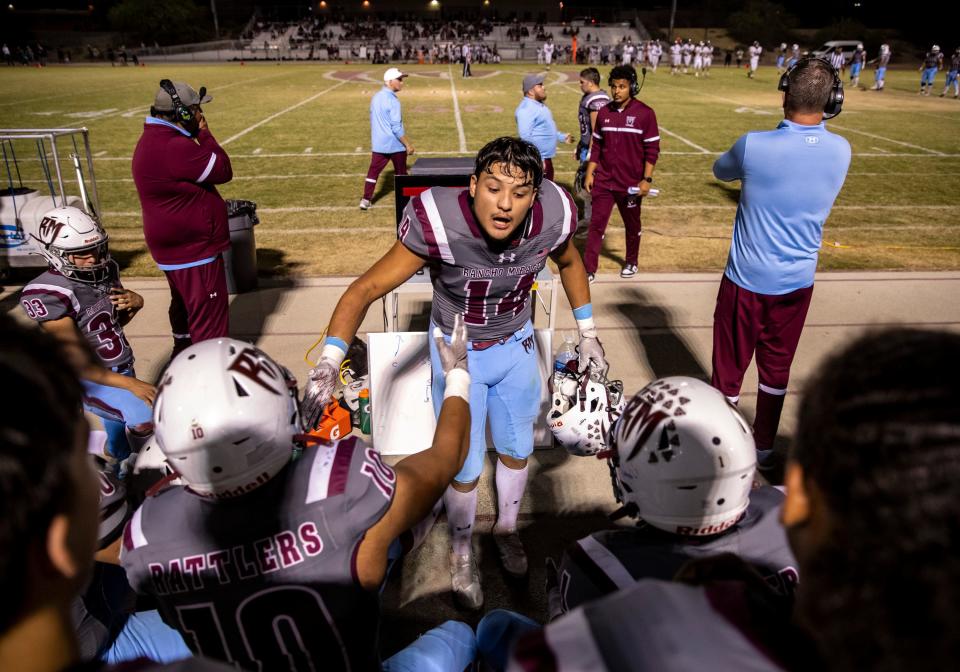 Rancho Mirage's Abel Flores (14) hypes up the defense before they go back out for their final set of downs on the field in the fourth quarter of their game in Rancho Mirage, Calif., Friday, Oct. 20, 2023.