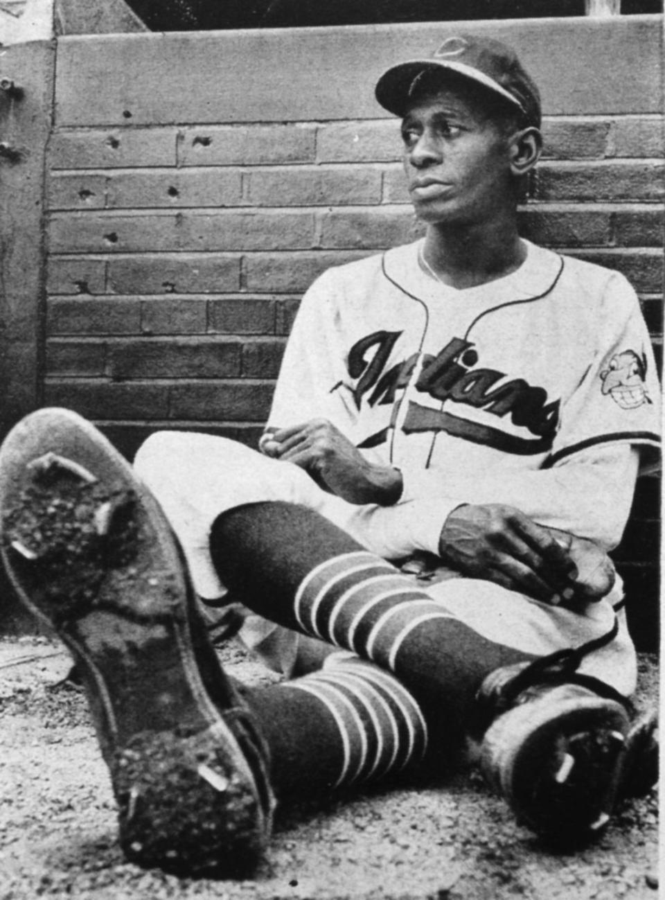 satchel paige sitting on a dirt mound with his legs crossed