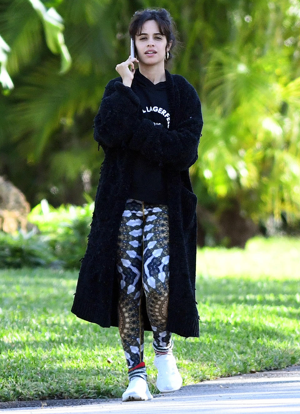 <p>Camila Cabello takes a call during a solo walk in Miami on Thursday.</p>