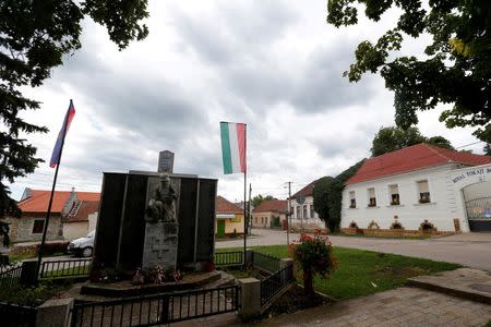 A view of the former home of the Zimmermann family in the village of Mad, Hungary, July 18, 2016, with a monument to the fallen heroes of the two World Wars in the foreground. Picture taken July 18. 2016. REUTERS/Laszlo Balogh