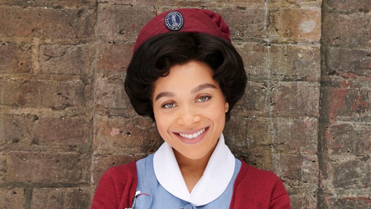  Leonie Elliot as Nurse Lucille Robinson wearing her nurses uniform and smiling at the camera . 