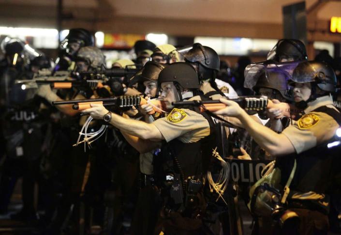 <p>Police officers point their weapons at demonstrators protesting against the shooting death of Michael Brown in Ferguson, Missouri August 18, 2014. Police fired tear gas and stun grenades at protesters on Monday after days of unrest sparked by the fatal shooting of unarmed black teenager Michael Brown by a white policeman. (Joshua Lott/Reuters) </p>