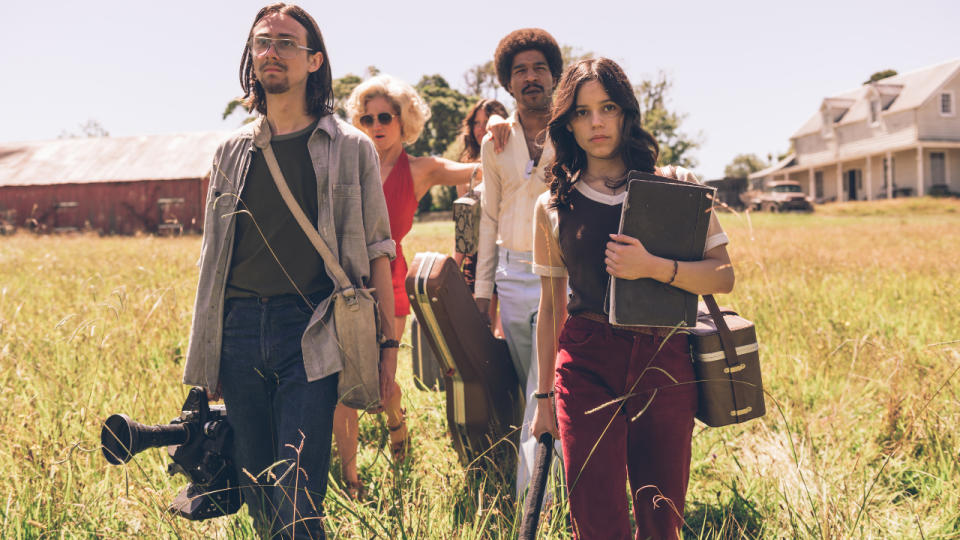 Owen Campbell, Brittany Snow, Mia Goth, Scott Mescudi, and Jenna Ortega carry equipment through a field in X.