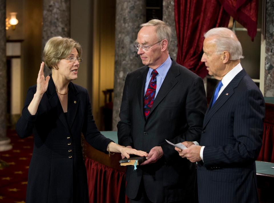 In this file photo from 2013, Vice President Joe Biden administers the Senate Oath to Sen. Elizabeth Warren, D-Mass., accompanied by her husband Bruce Mann, during a mock swearing in ceremony on Capitol Hill in Washington, Thursday, Jan. 3, 2013, as the 113th Congress officially began.