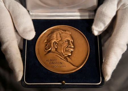 Fine-art handler Tom Richardson displays The Albert Einstein Award given to the British theoretical physicist Stephen Hawking ahead of an auction of items from Hawkings' personal estate at Christie's in London, Britain October 30, 2018. REUTERS/Toby Melville