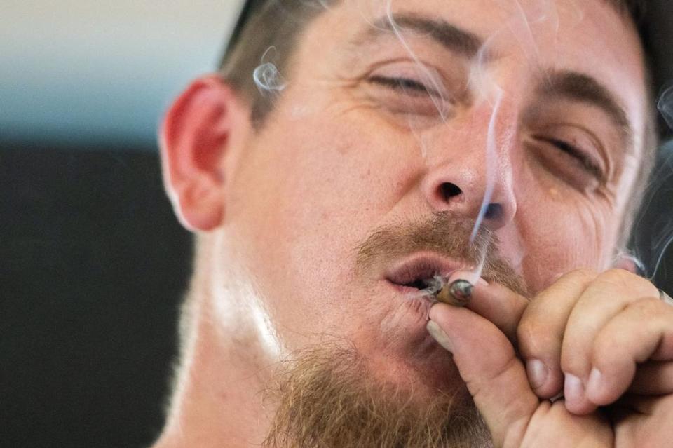 John Mitchell smokes a prerolled joint in the cannabis consumption lounge on Tuesday during the California State Fair in Sacramento. Mitchell said using cannabis products helps him wind down and gives him a sense of “mental bliss.”
