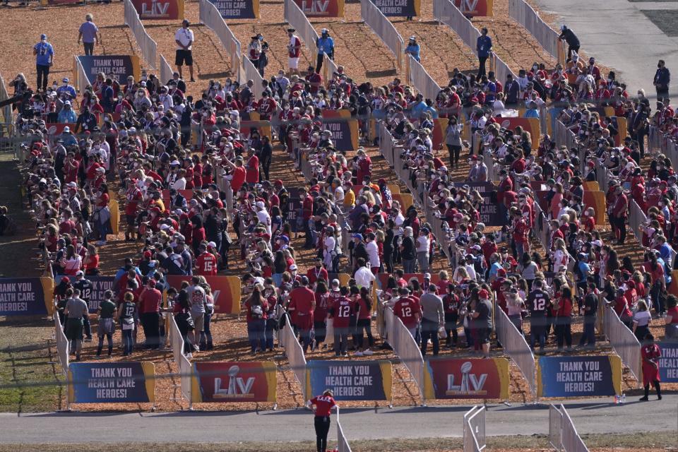 Fans social distance as they watch a stage show before the NFL Super Bowl 55 football game between the Kansas City Chiefs and Tampa Bay Buccaneers, Sunday, Feb. 7, 2021, in Tampa, Fla. (AP Photo/Charlie Riedel)