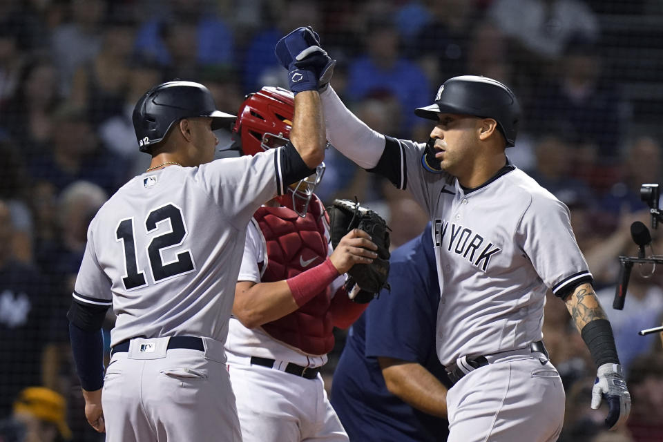 New York Yankees' Isiah Kiner-Falefa (12) celebrates with Marwin Gonzalez, right, after Gonzalez hit a two-run home run against the Boston Red Sox during the third inning of a baseball game Tuesday, Sept. 13, 2022, in Boston. Red Sox's Reese McGuire is at rear. (AP Photo/Steven Senne)