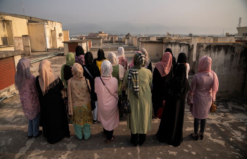 Group of Afghan women prosecutors stand on a rooftop overlooking Islamabad