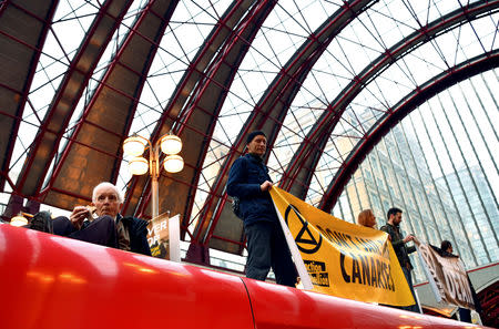 Demonstrators stand on top of a DLR train as they block the traffic at Canary Wharf Station, during the Extinction Rebellion protest in London, Britain April 25, 2019. REUTERS/Dylan Martinez