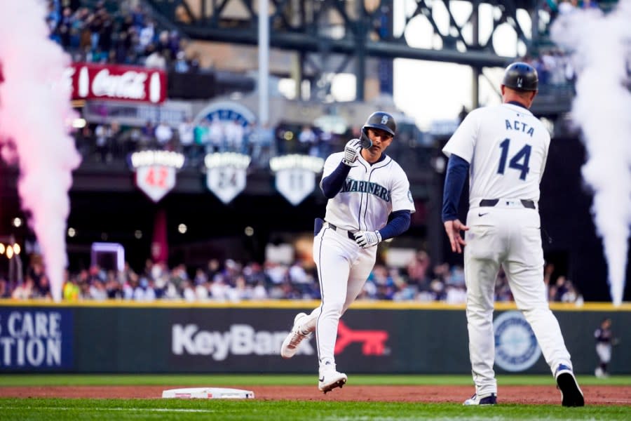 Seattle Mariners’ Dominic Canzone celebrates with third base coach Manny Acta (14) after hitting a three-run home run against the Cleveland Guardians during the second inning of a baseball game Monday, April 1, 2024, in Seattle. (AP Photo/Lindsey Wasson)