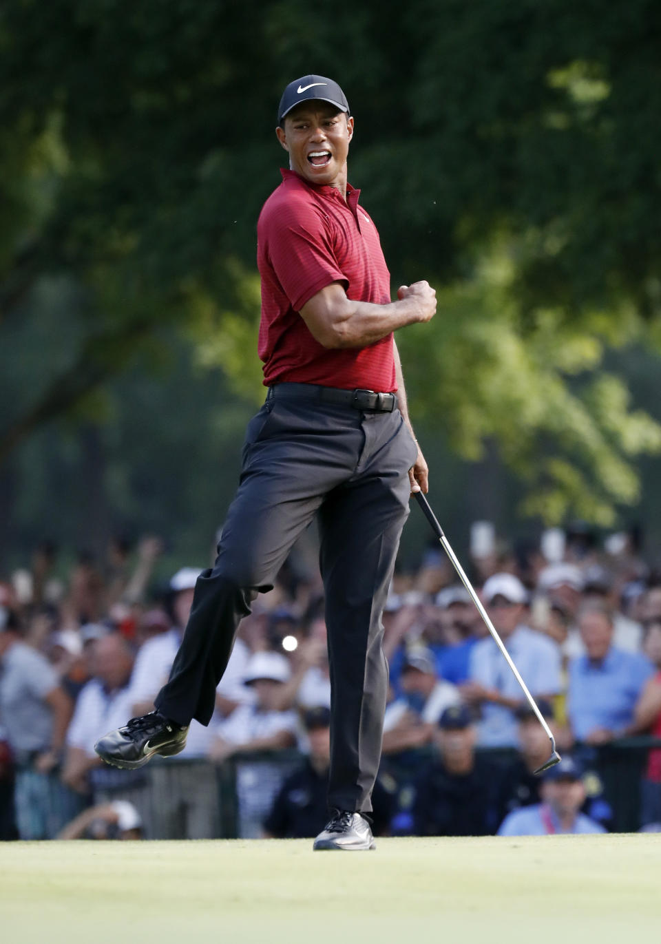 Tiger Woods celebrates after making a birdie putt on the 18th green during the final round of the PGA Championship golf tournament at Bellerive Country Club, Sunday, Aug. 12, 2018, in St. Louis. (AP Photo/Brynn Anderson)