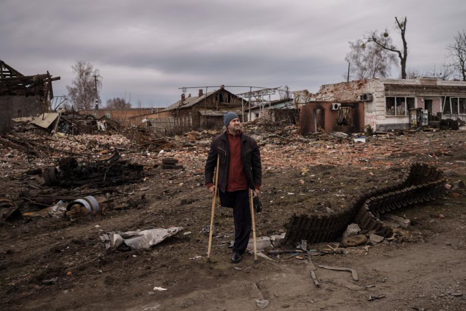 Man next to remains of a Russian tank